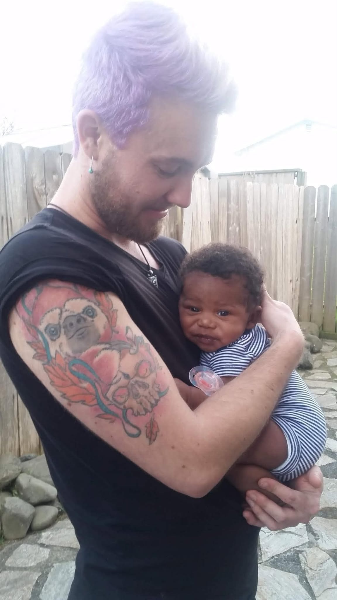 Adult holding a baby during a quiet outdoor family moment