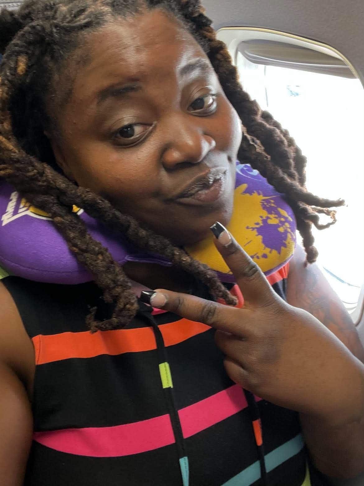 Community member sharing a travel selfie inside an airplane