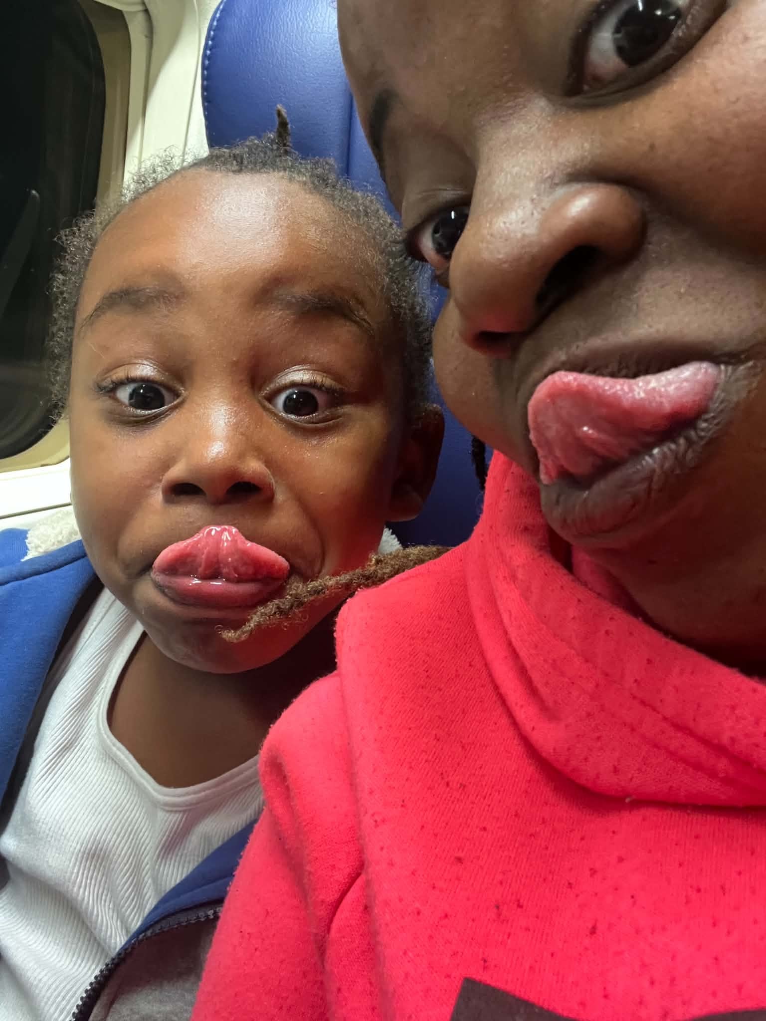 Adult and child sharing a playful moment on an airplane