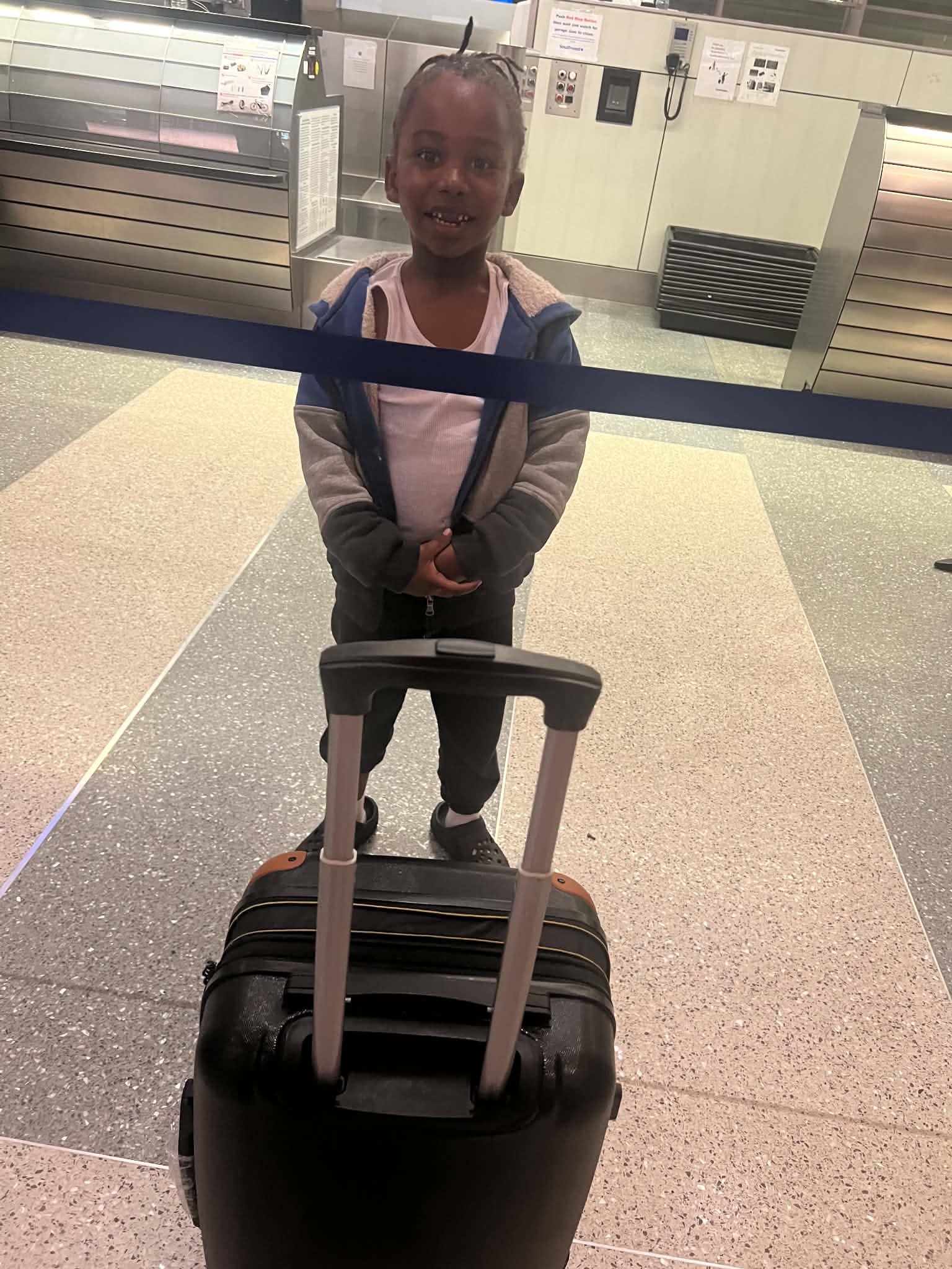 Child standing with luggage during a travel adventure