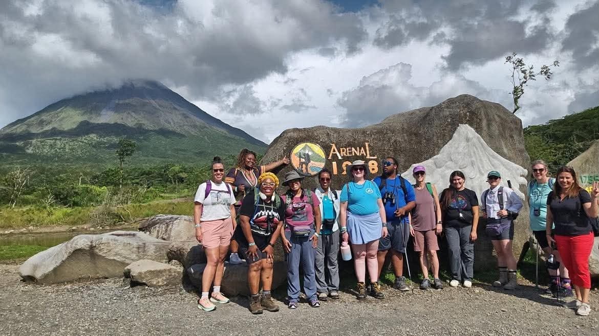 Travel group gathered at the Arenal Volcano landmark