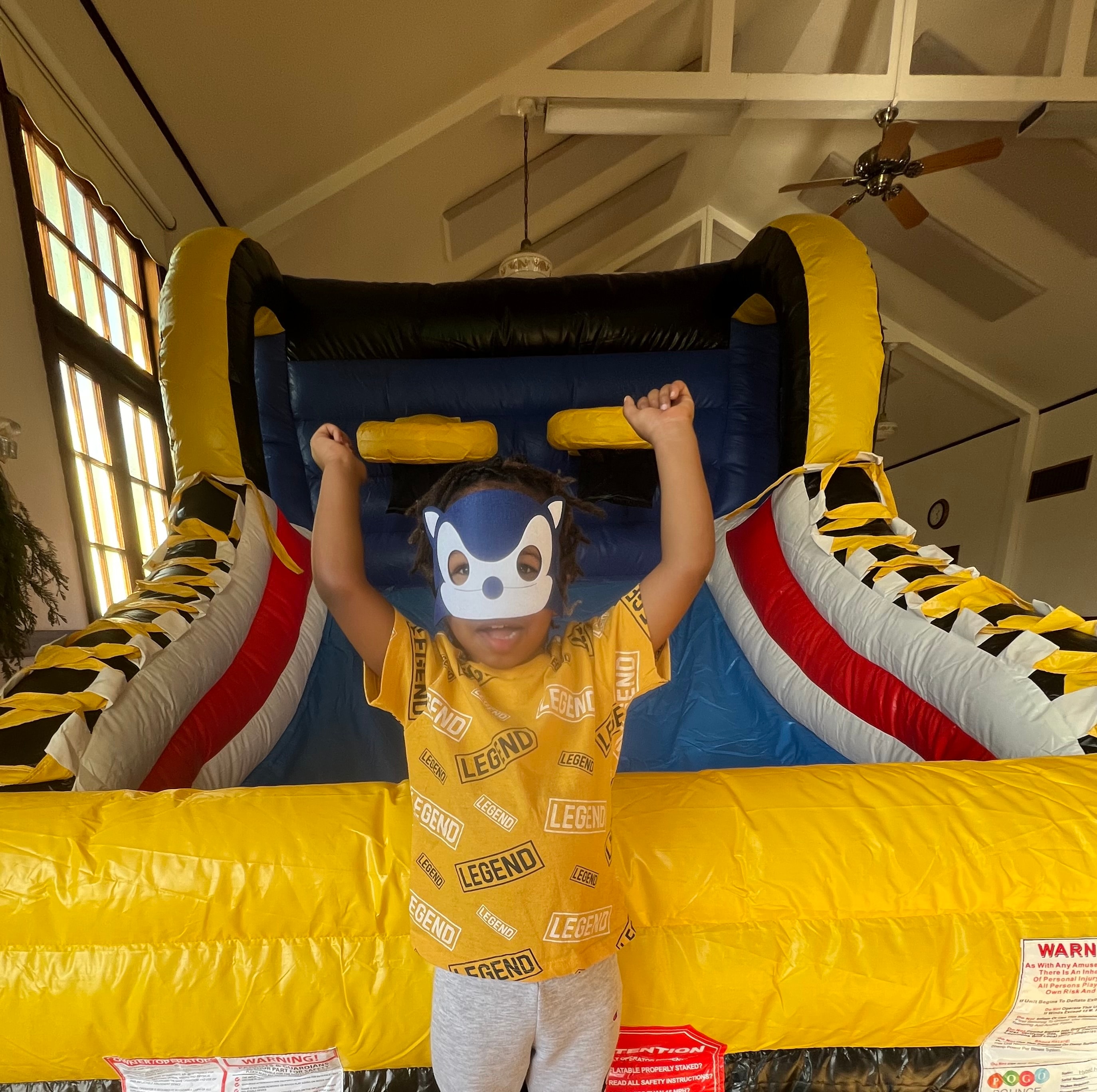 Child wearing a costume mask at a bounce house
