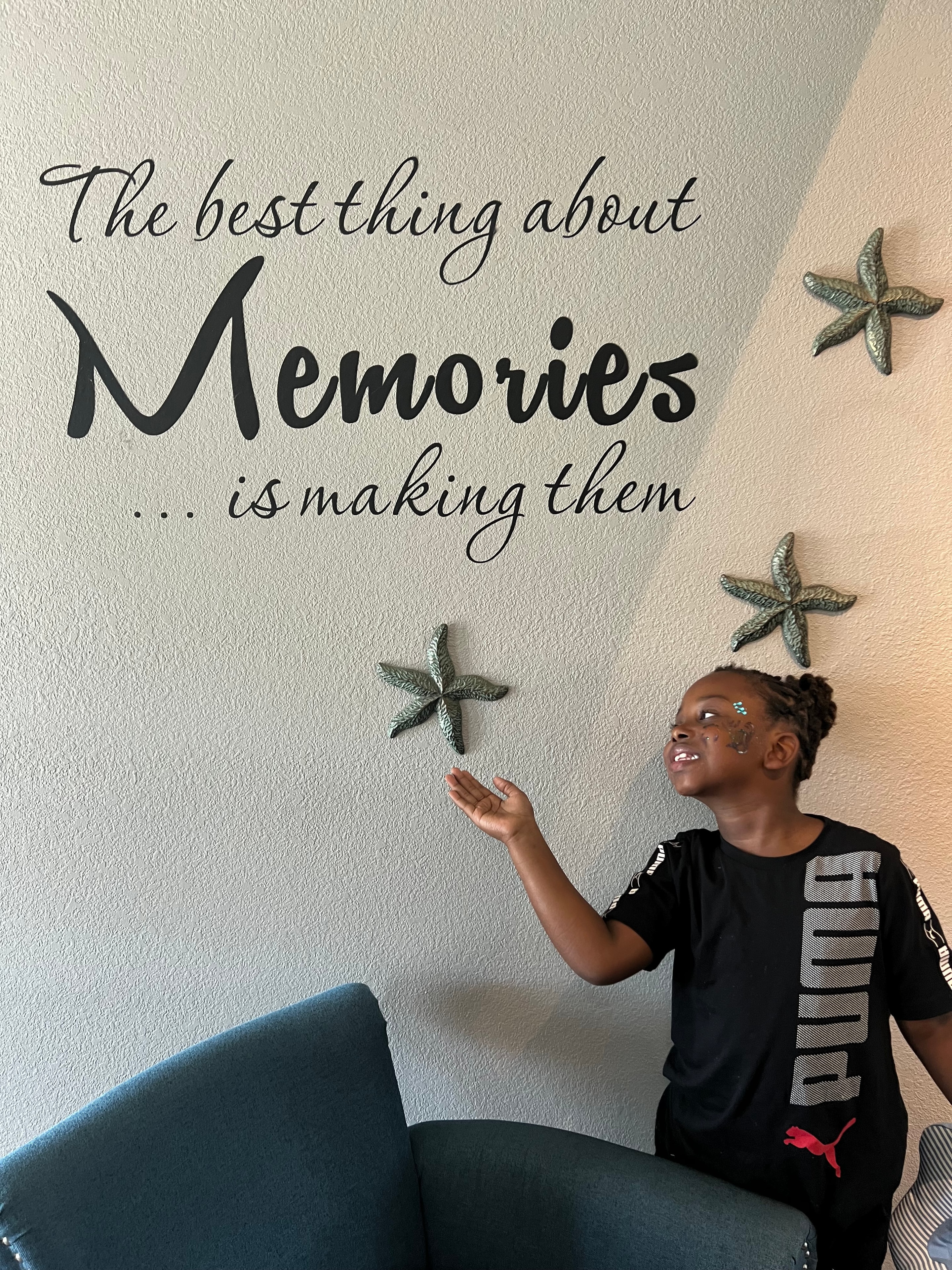Child beside an empowerment wall with starfish decorations