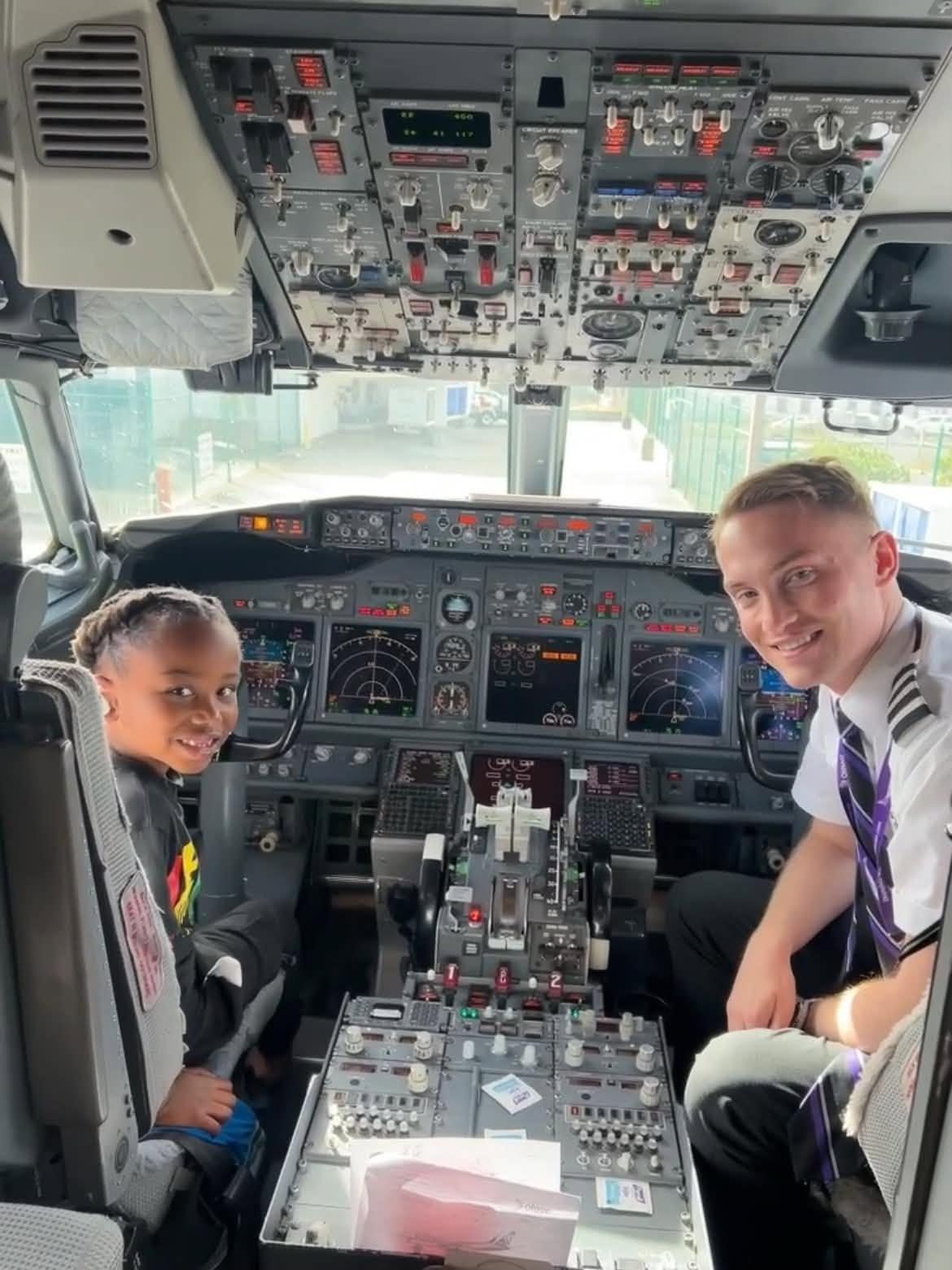 Child visiting an airplane cockpit with a pilot