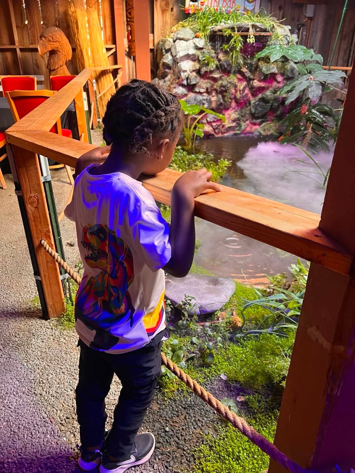 Child exploring an indoor tropical water feature