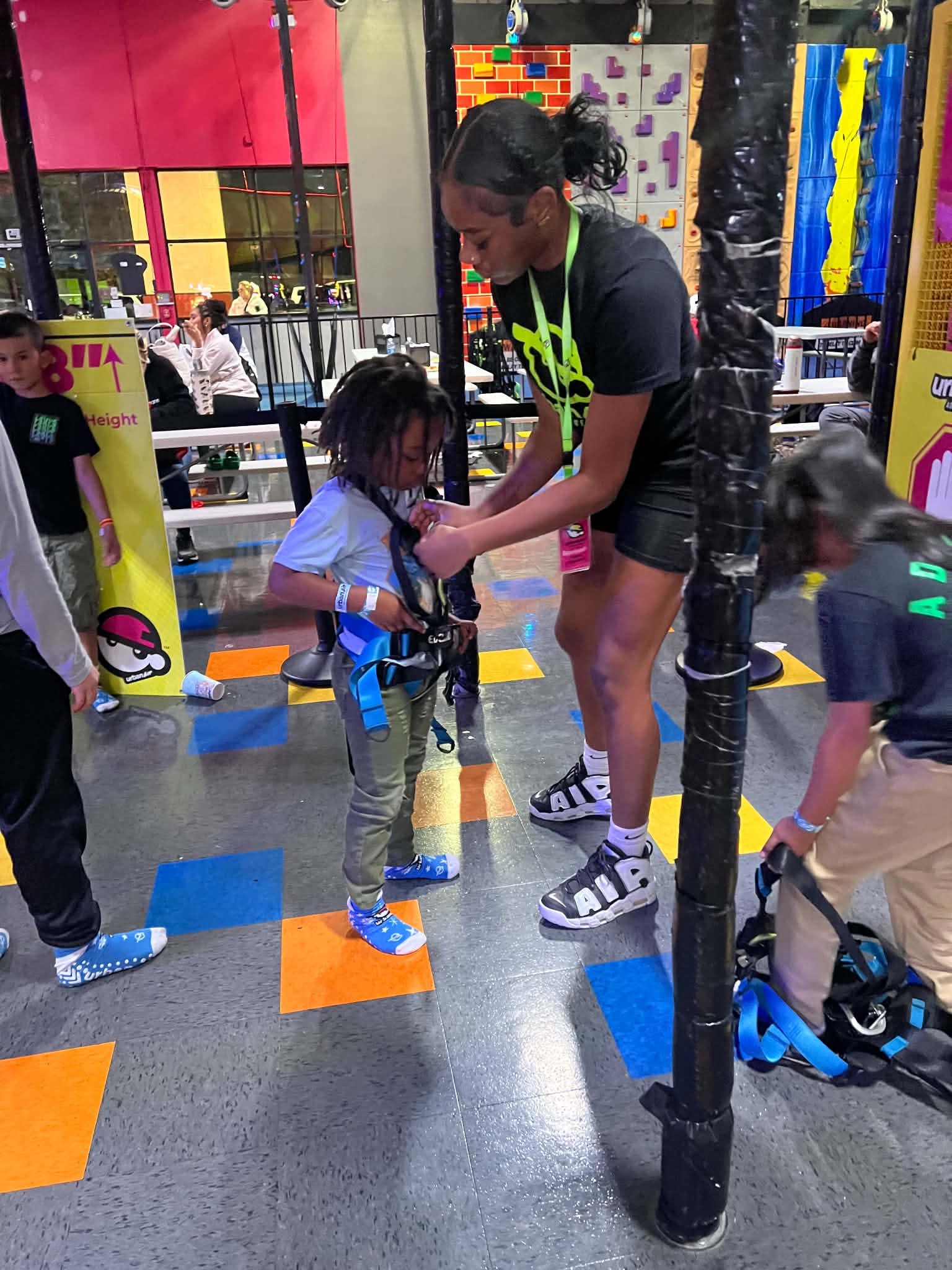 Child preparing for an indoor climbing adventure with an instructor