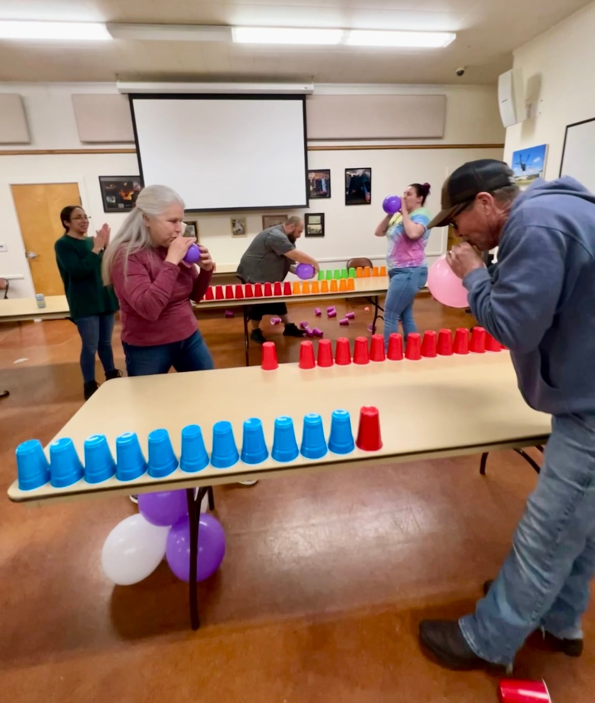 Community members taking part in a balloon and cup game