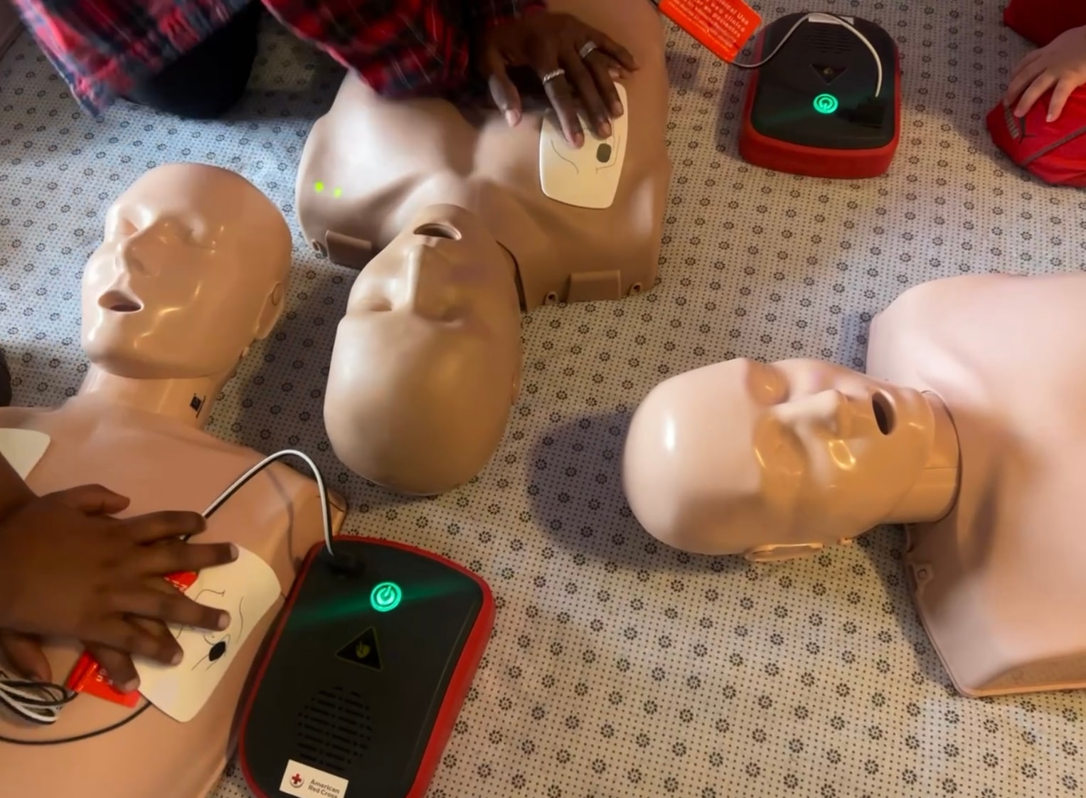 Community members practicing CPR skills with training mannequins