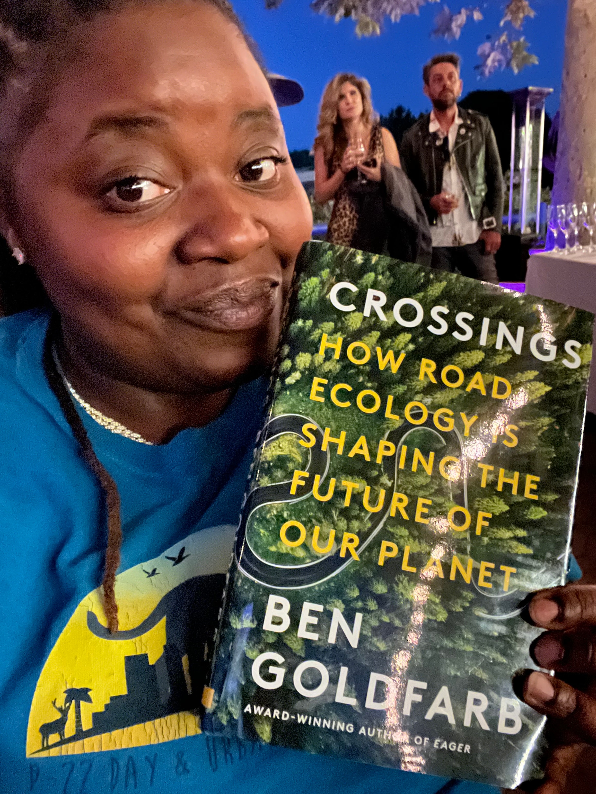 Community member sharing a book about wildlife and ecology outdoors
