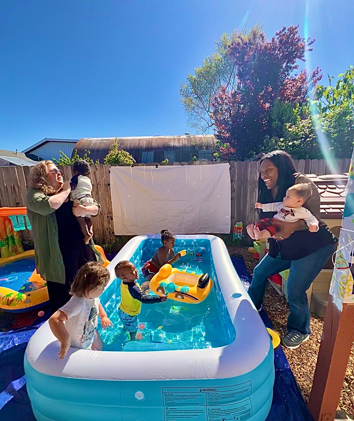 Families and children enjoying a backyard pool day