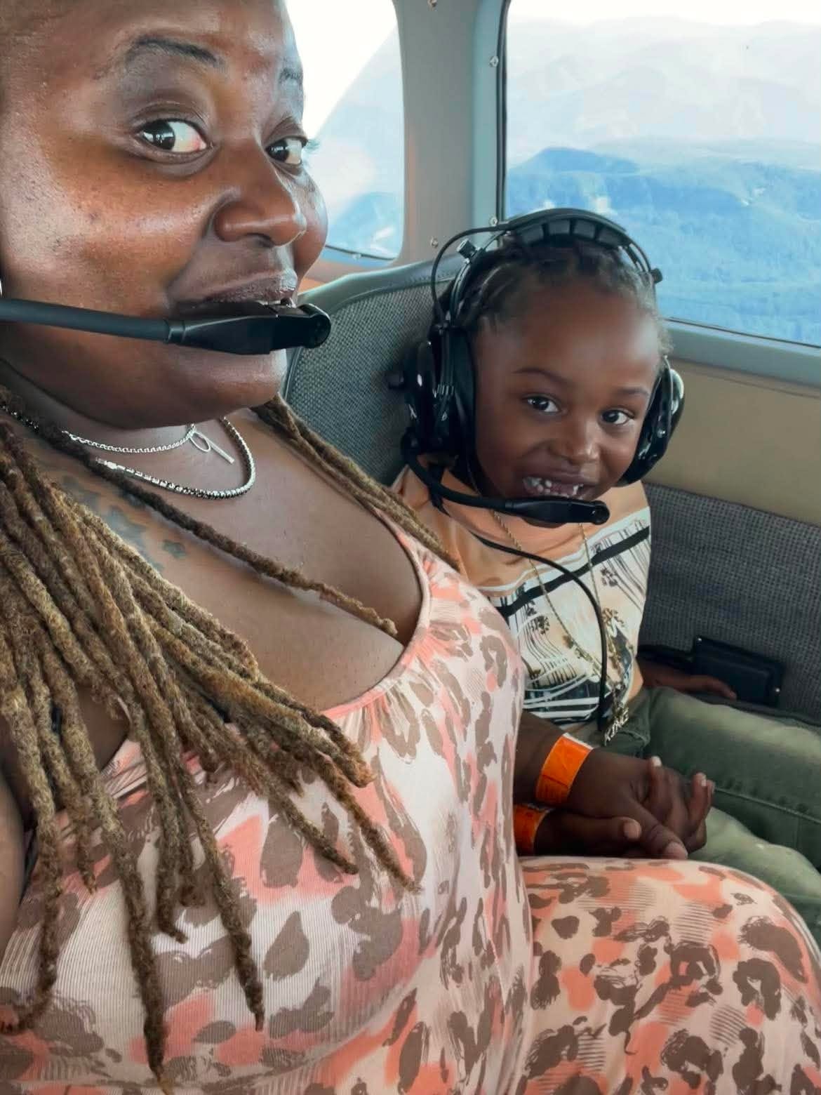 Adult and child wearing headsets inside an airplane