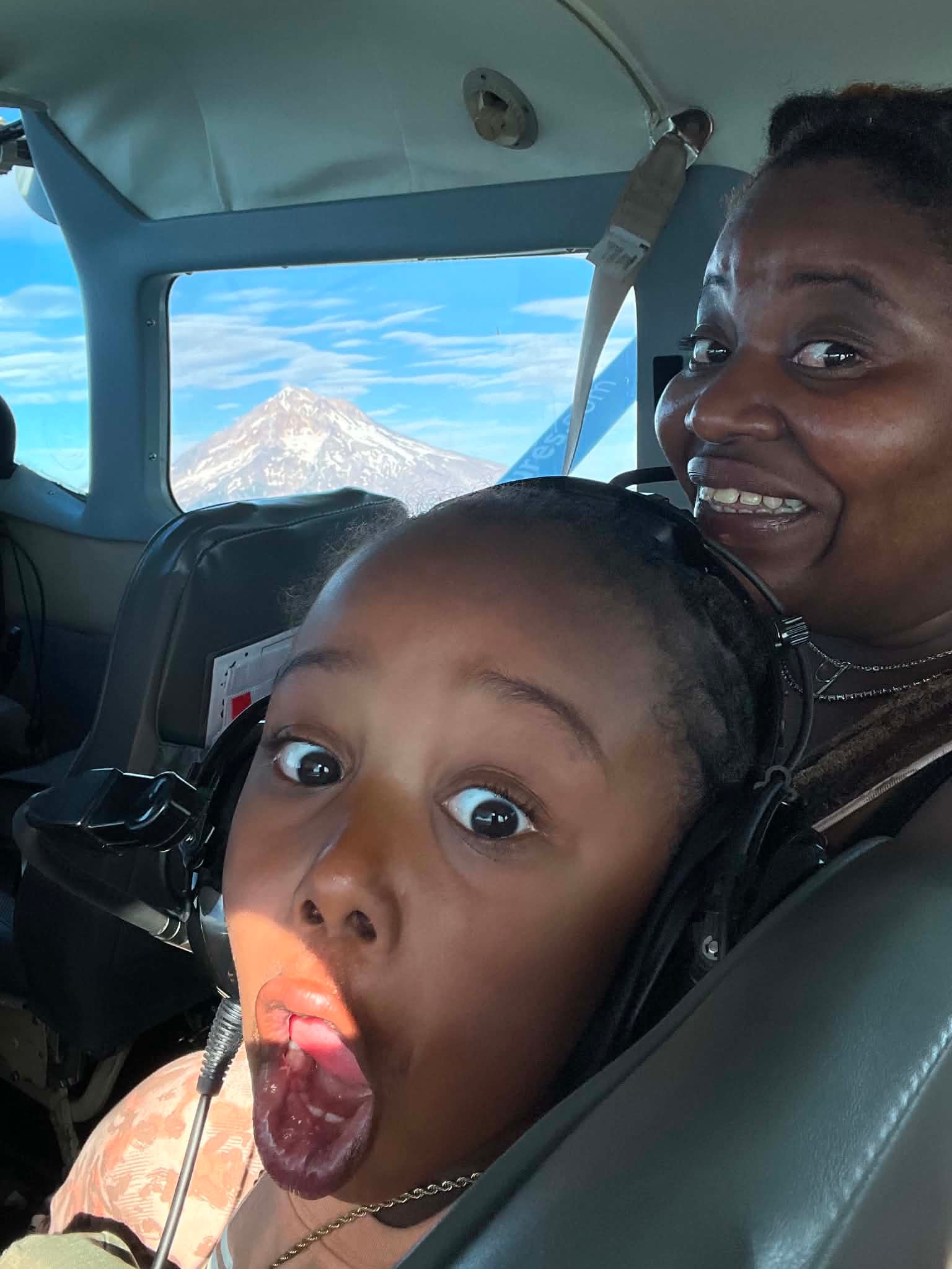 Family enjoying a small-aircraft adventure with a mountain view