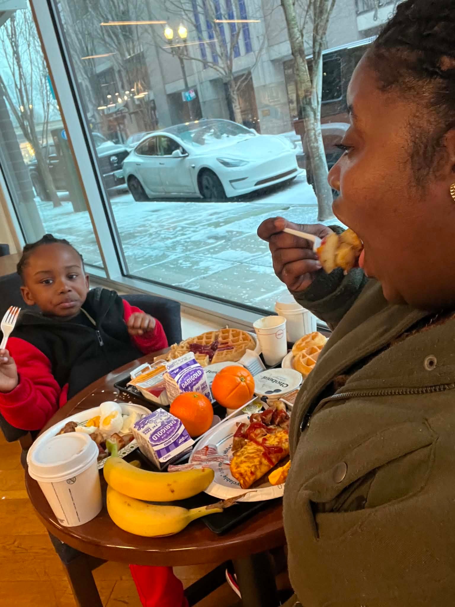 Adult and child sharing breakfast together at a café