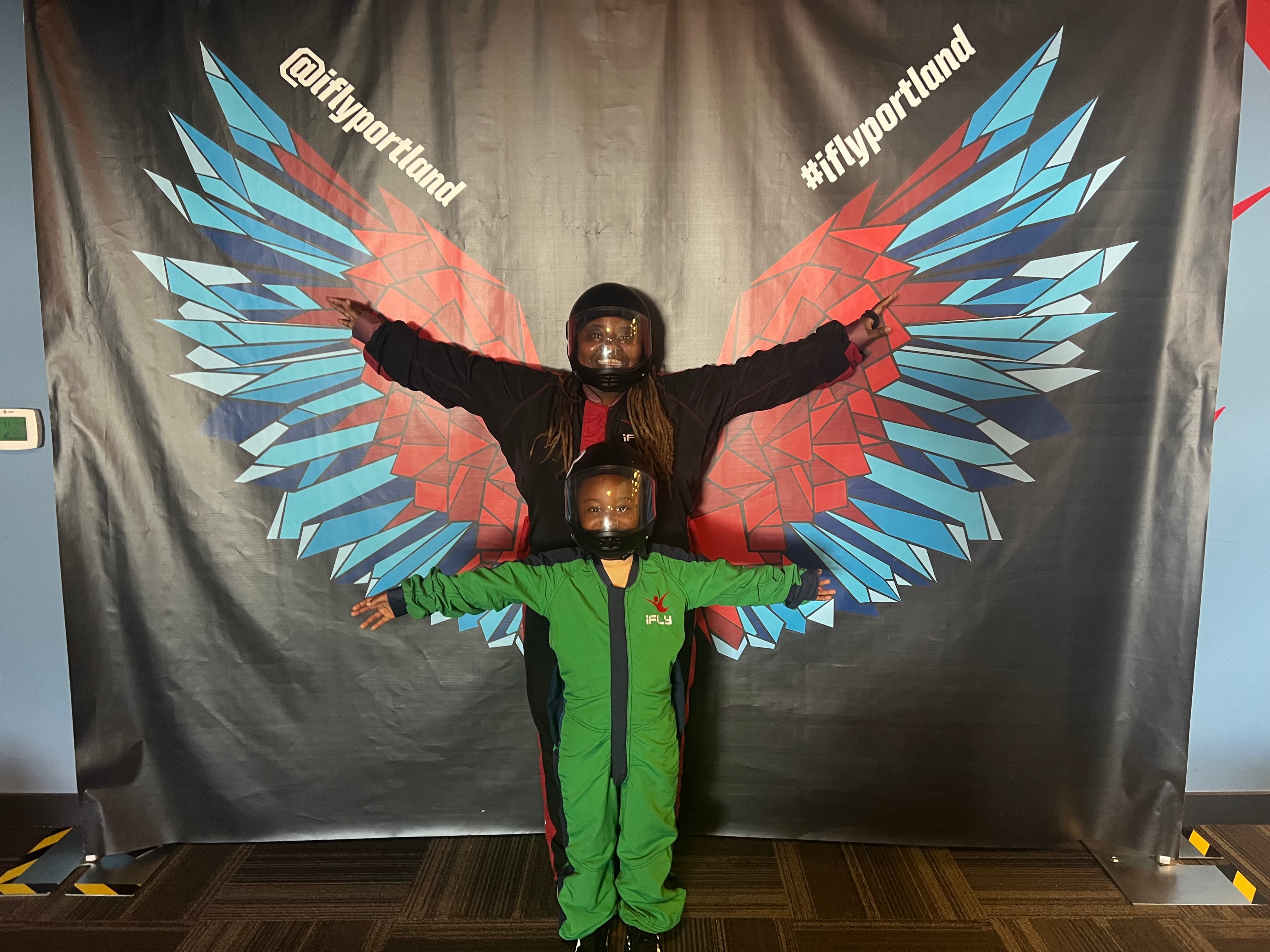 Family in flight suits posing at an indoor skydiving experience