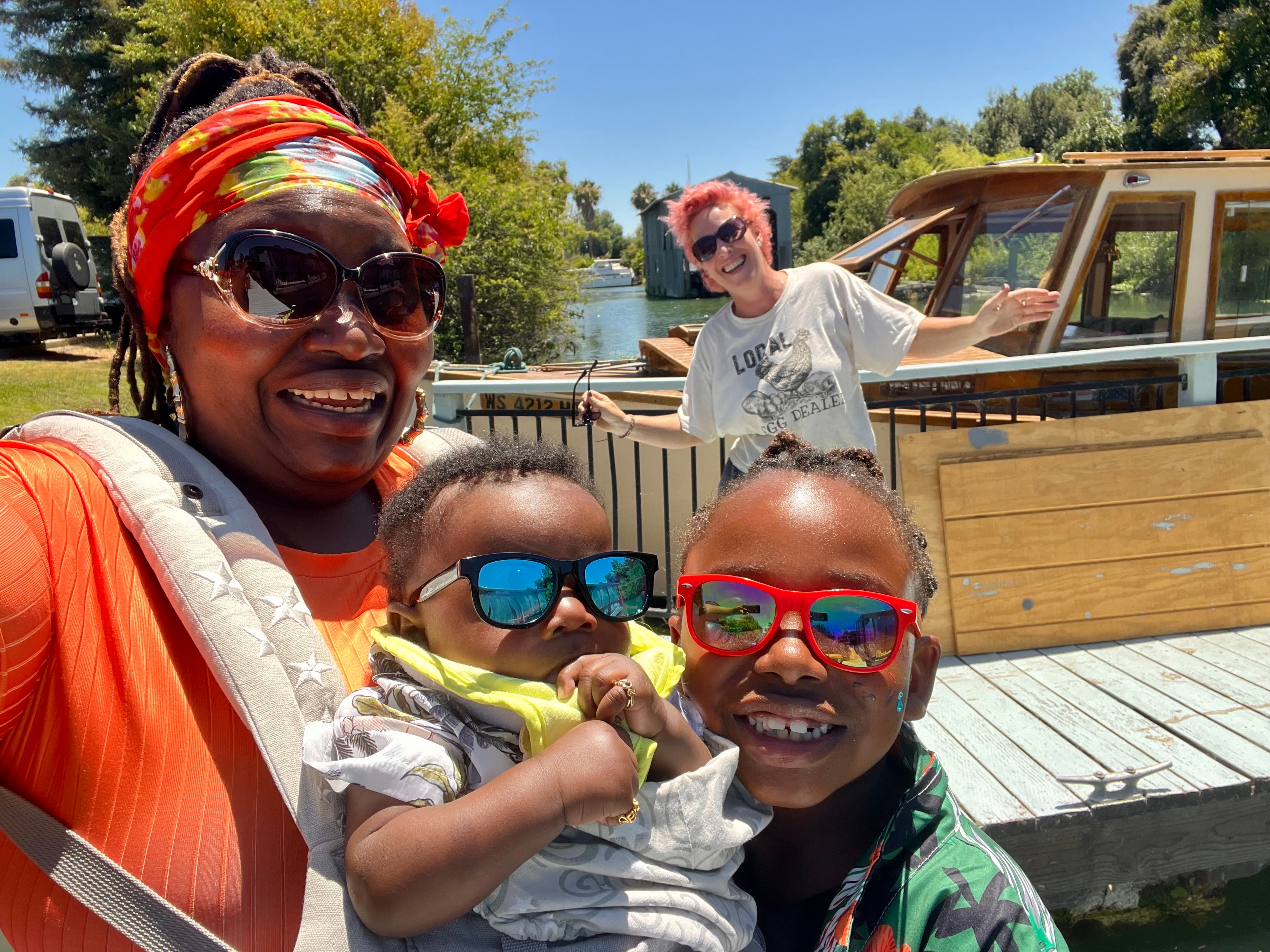 Family smiling together near a waterfront boat
