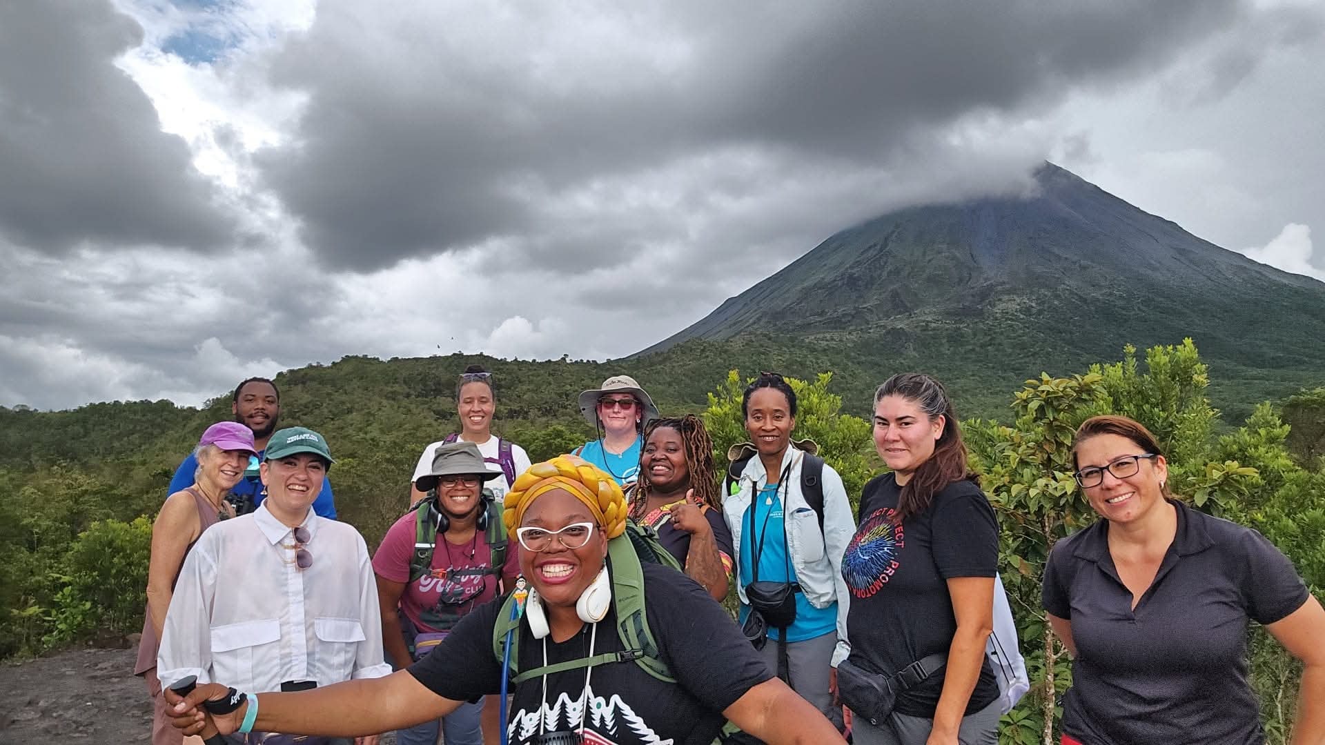 Community group hiking together in front of a volcanic mountain