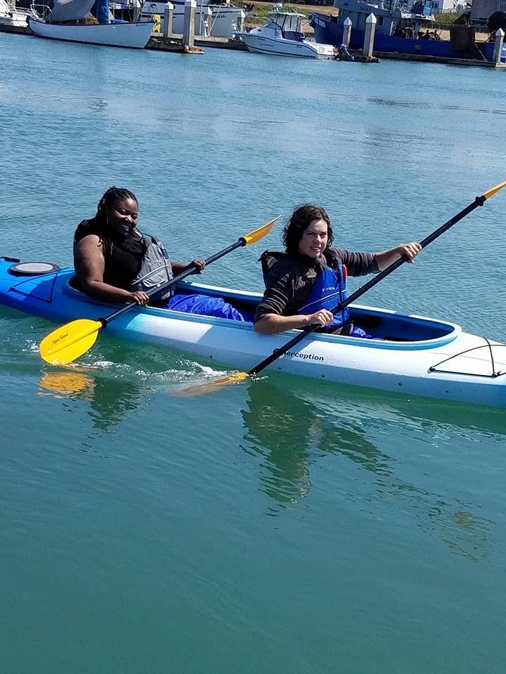 Two people kayaking together on a calm harbor