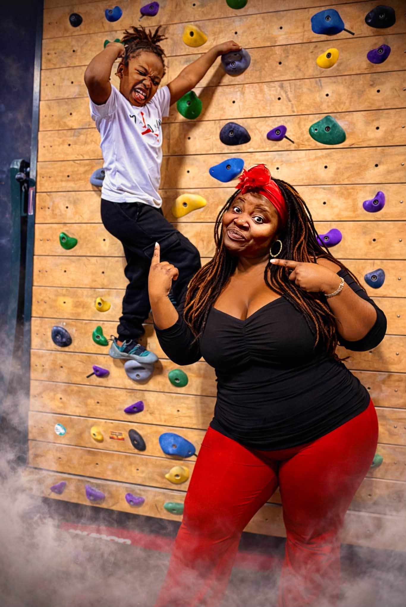 Adult and child enjoying an indoor climbing adventure