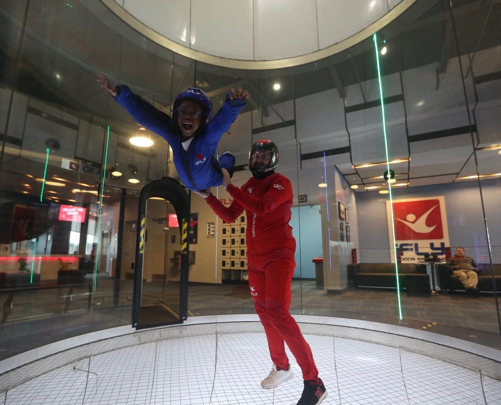 Child enjoying indoor skydiving with an instructor