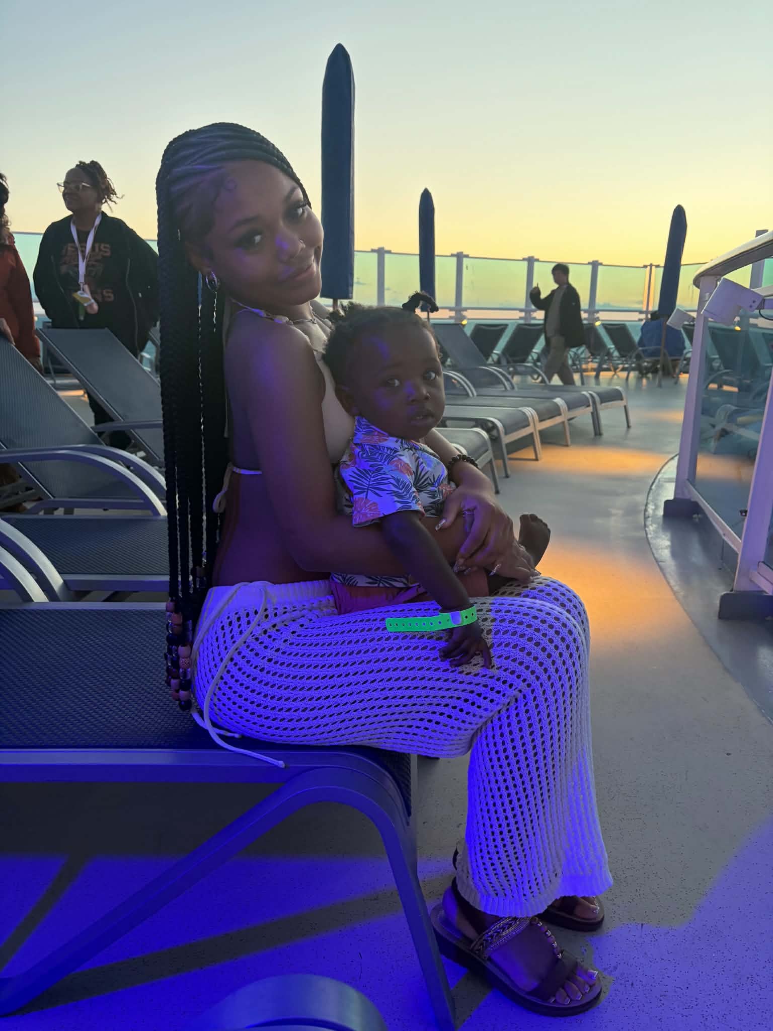 Mother holding child on a sunset deck