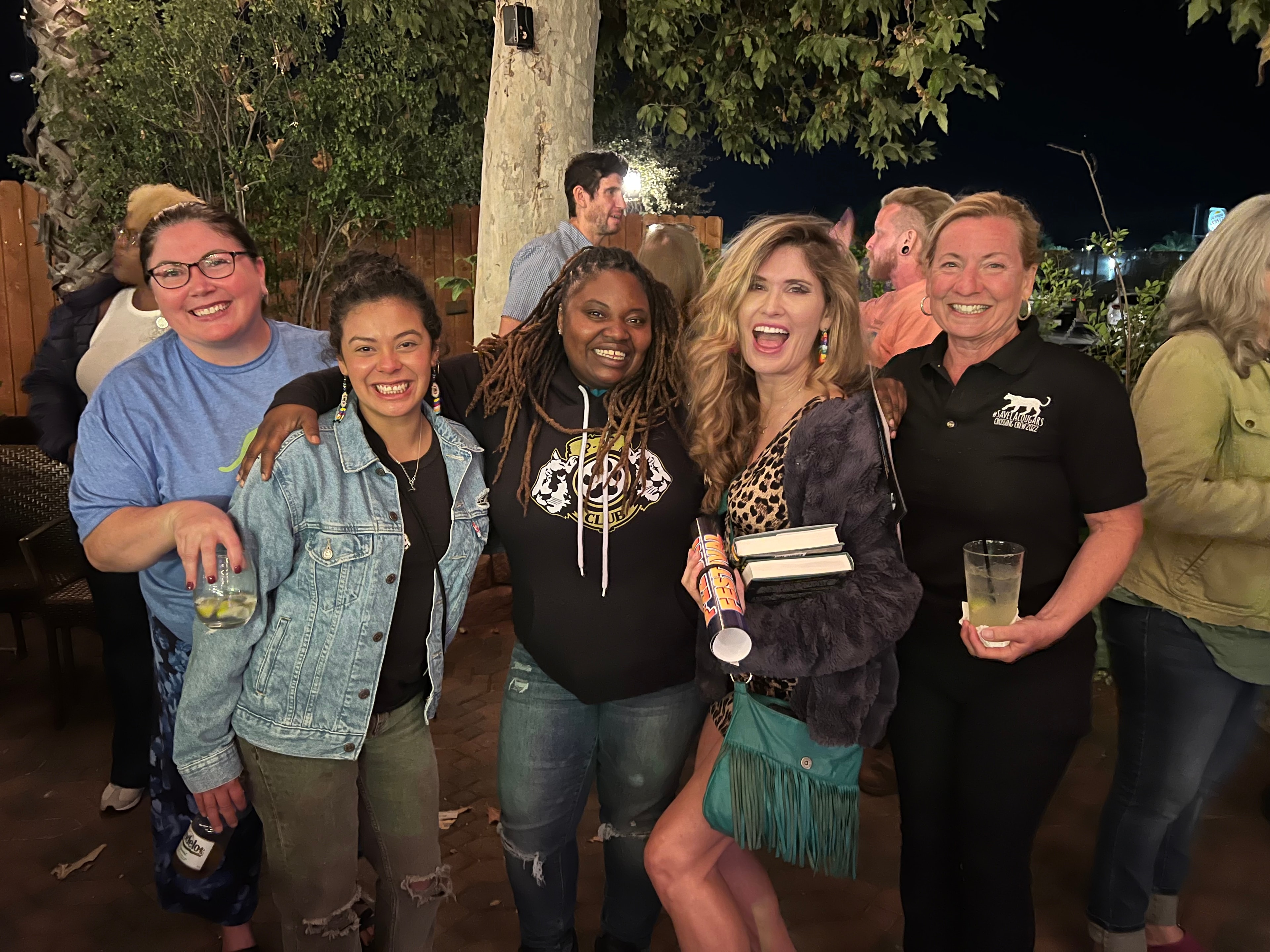 Friends smiling together at a nighttime community gathering