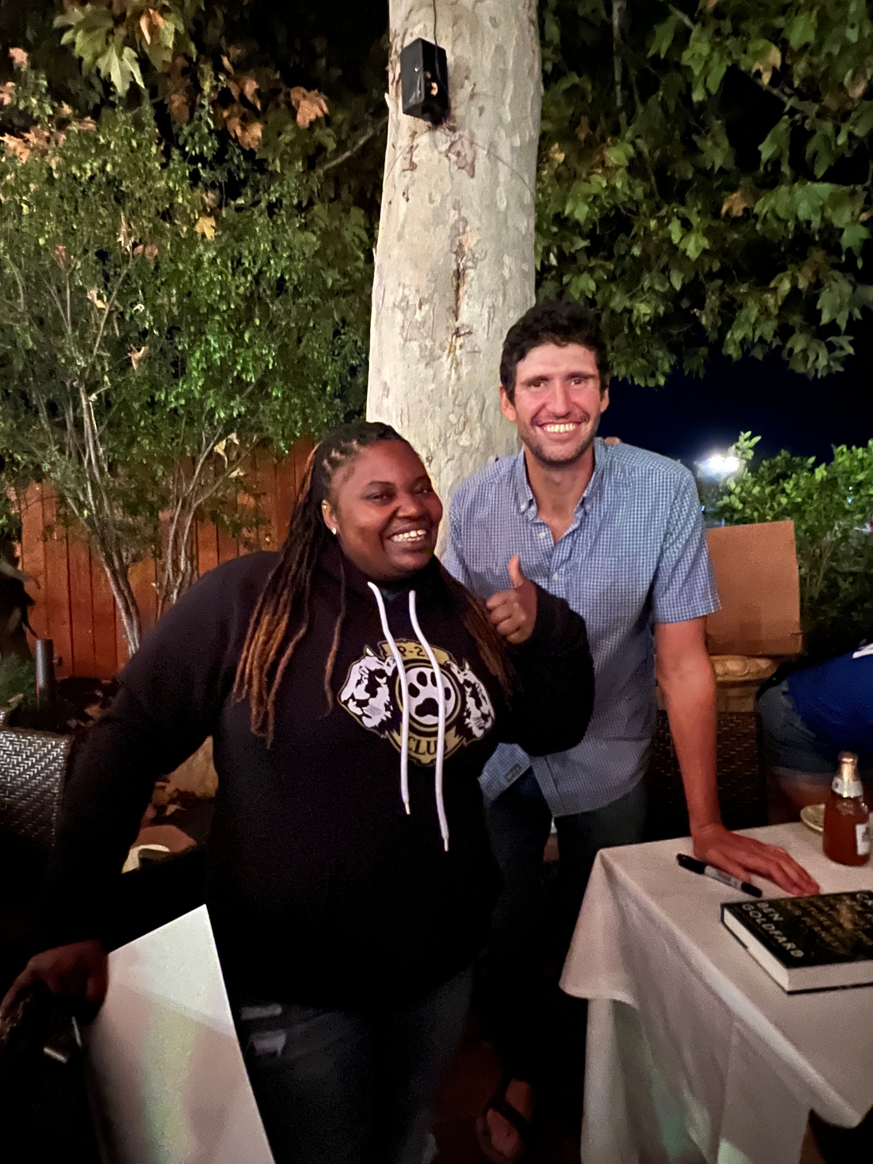 Two friends smiling at a nighttime community event