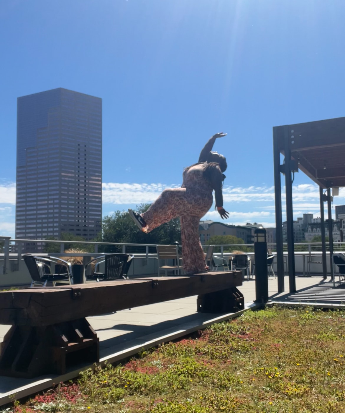Dancer moving on a rooftop with city skyline