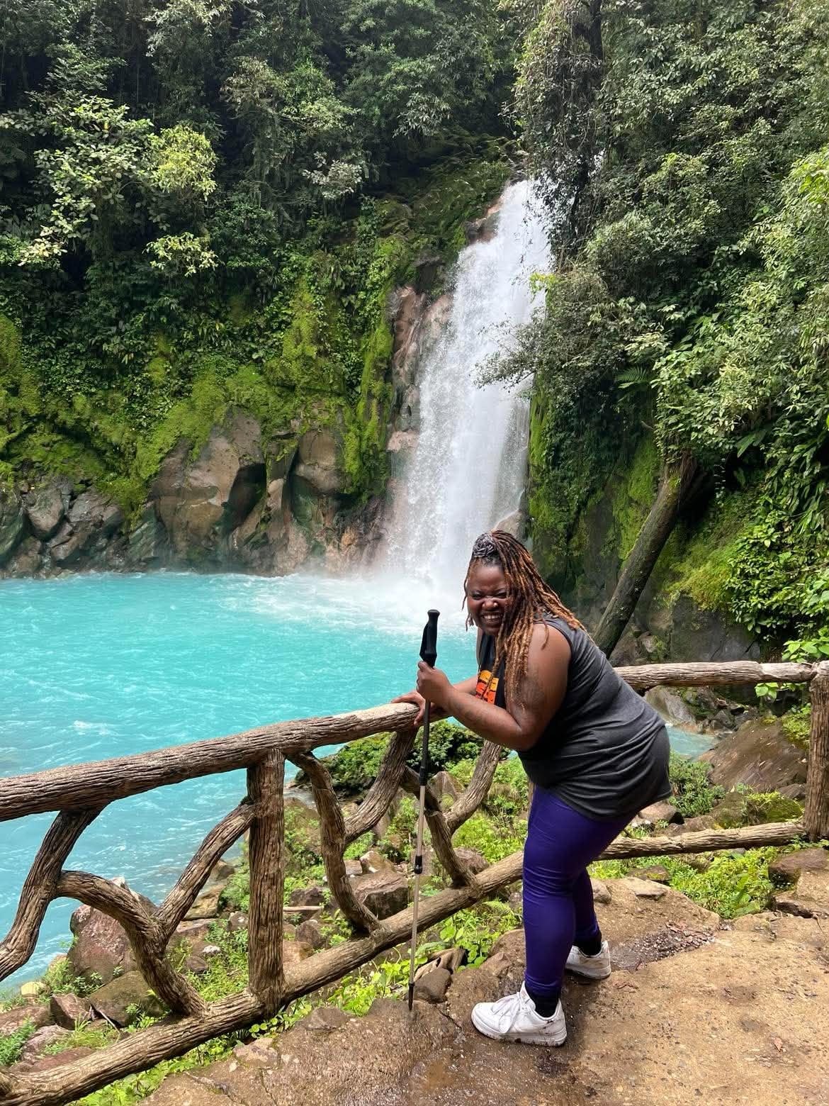 Community member enjoying a turquoise waterfall hike