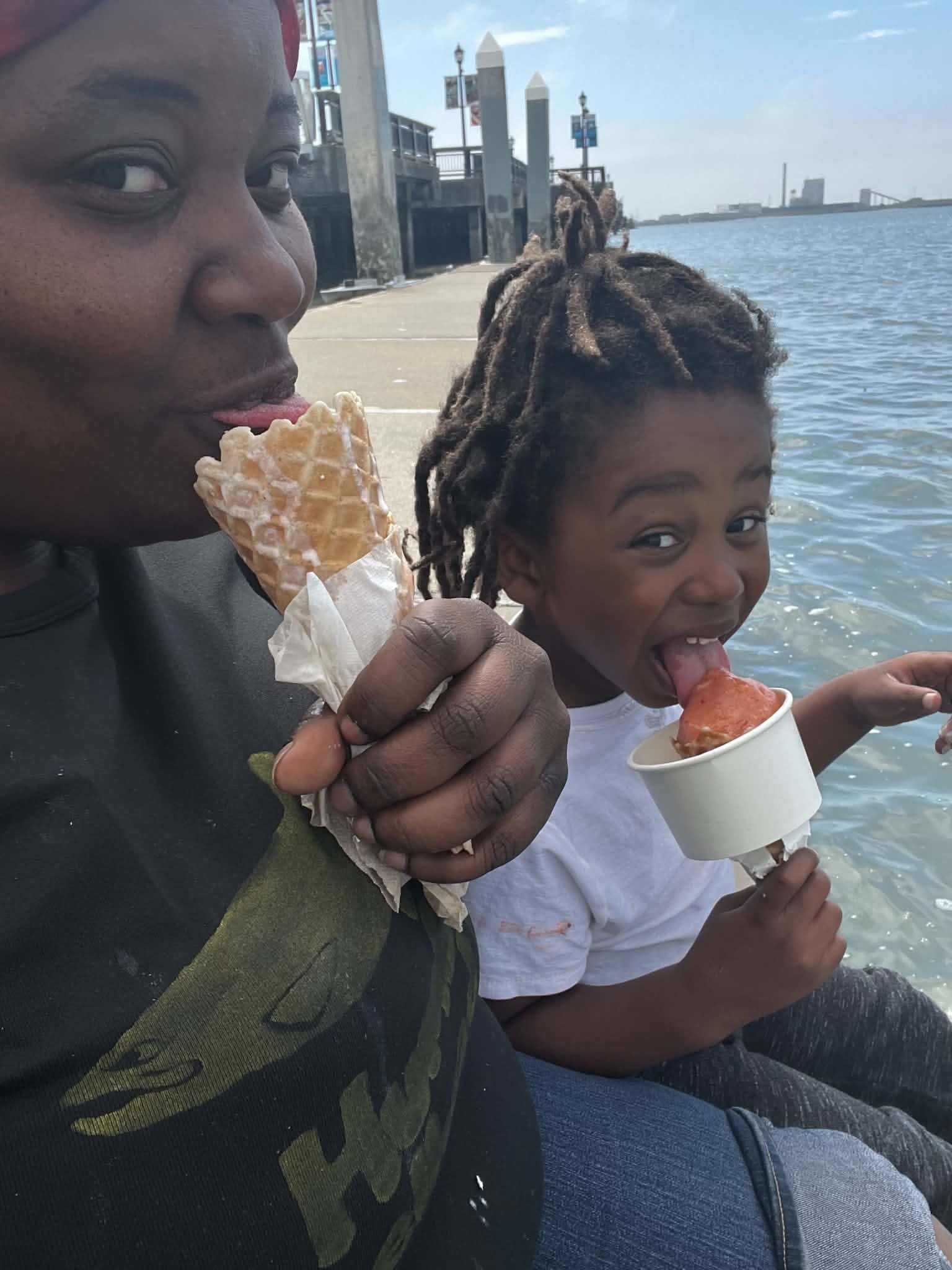 Adult and child enjoying ice cream at the waterfront